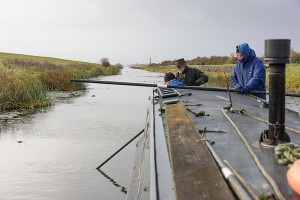 Olive Emily's volunteer crew man the poles to extract her from the silt.